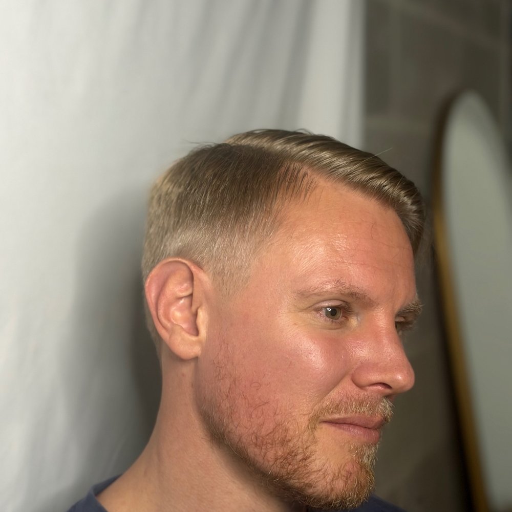 Skin fade with a side part and beard trim